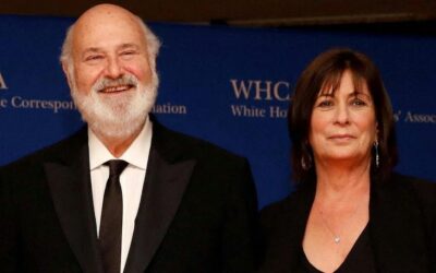 Rob Reiner and his wife Michele Singer Reiner smiling together at a formal event with a blue background